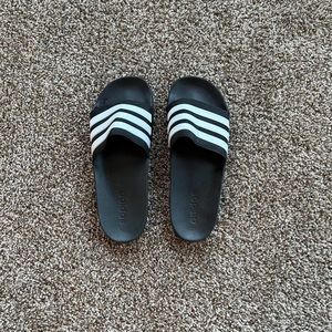 Black and White Adidas slides.